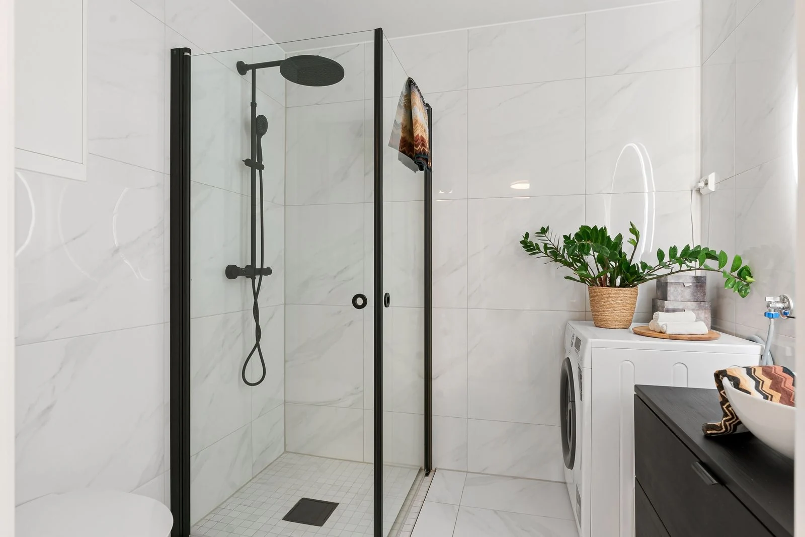 Bright and contemporary bathroom featuring a shower and laundry area in a minimalist design