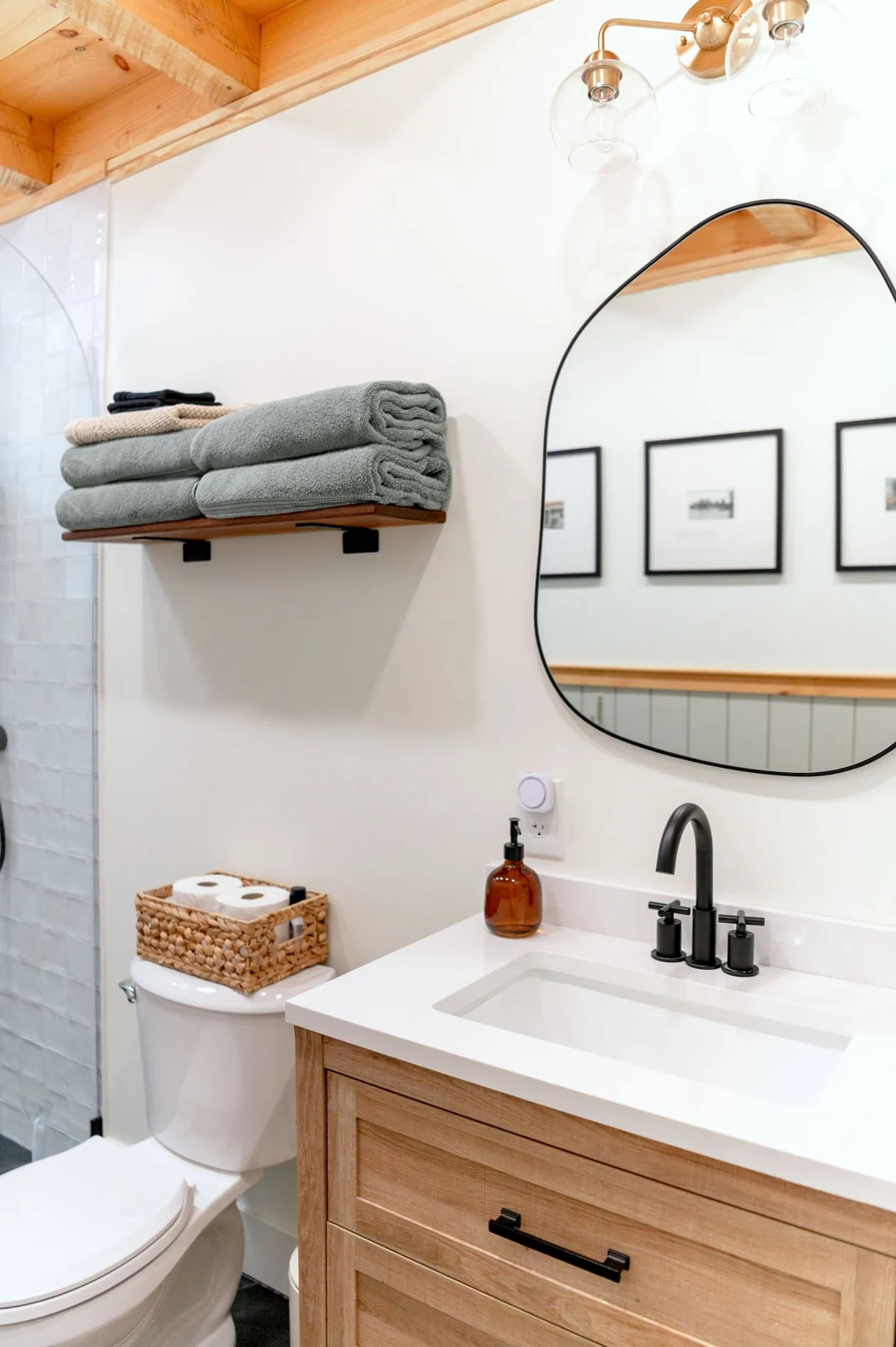 A modern rustic bathroom featuring minimalist decor, wooden accents, and elegant fixtures
