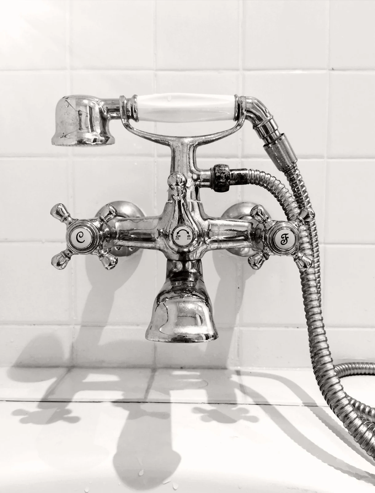 Elegant vintage chrome faucet in black and white, showcasing classic design and plumbing details