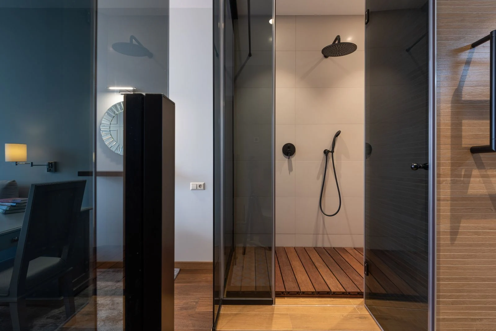 Clean empty shower cabin with wooden floor and glass walls placed in contemporary apartment