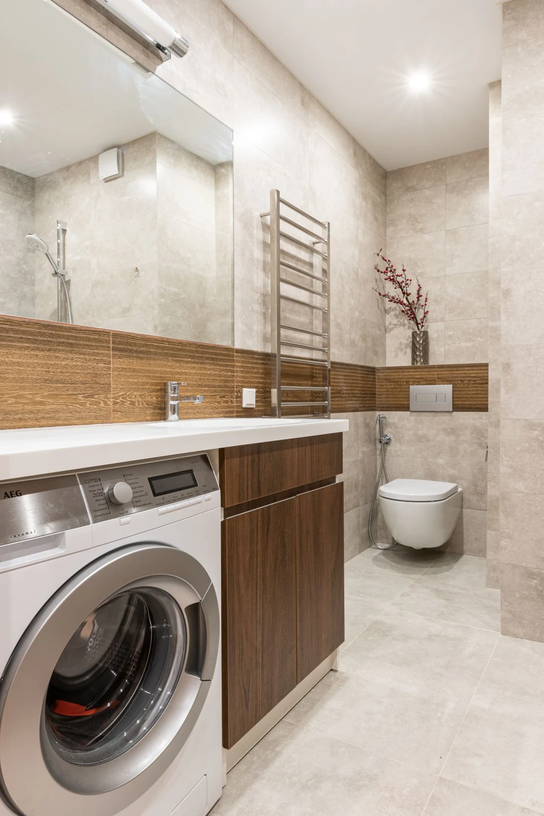 Contemporary bathroom interior featuring a washing machine, toilet bowl, and sleek design elements