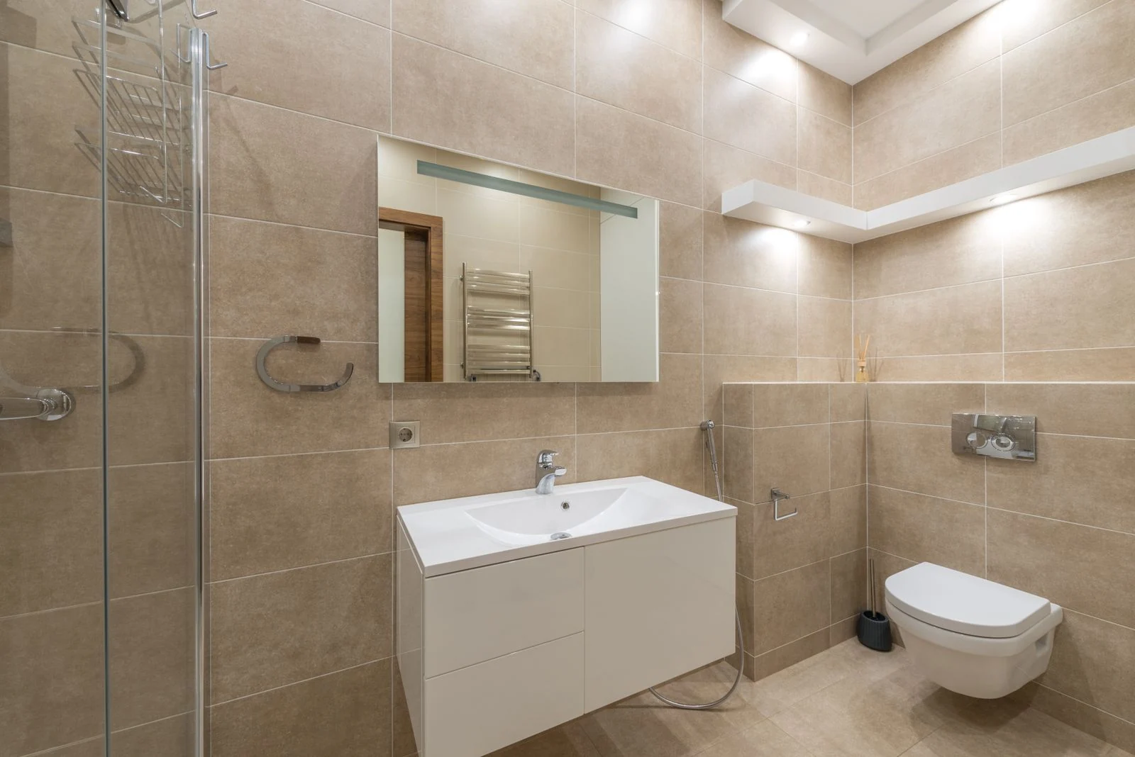 Elegant bathroom with modern fixtures and beige tiles