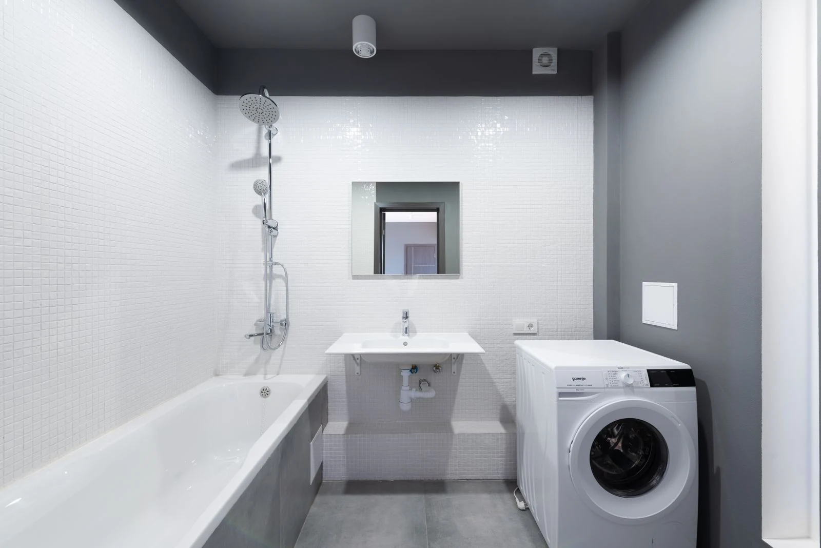 Modern bathroom design featuring bathtub, sink, and washing machine